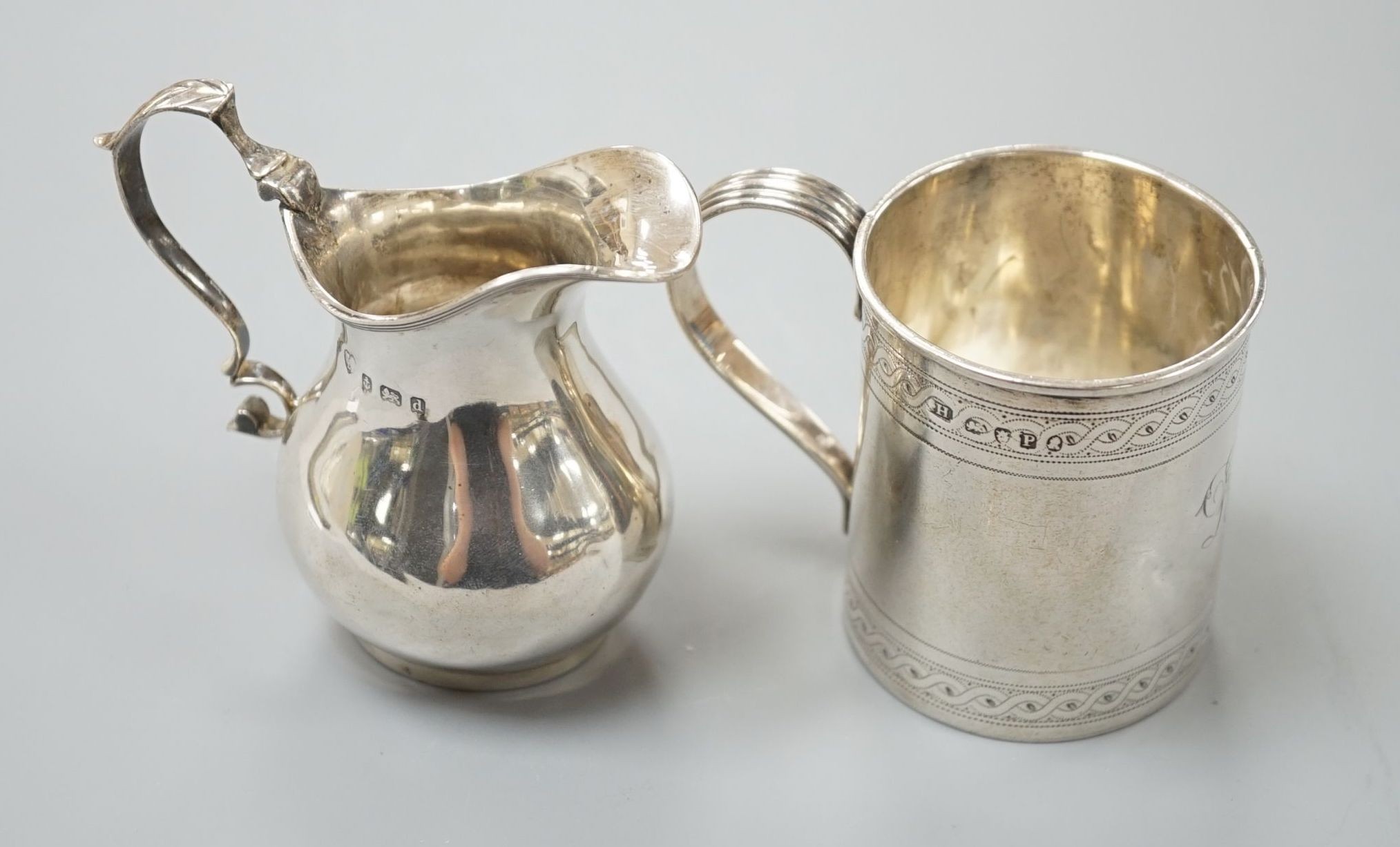 A George III engraved silver christening mug, London, 1810, 67mm and a later silver cream jug, 5oz.